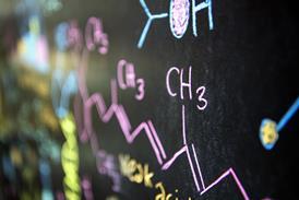 ADENINE close-up photograph of a chemical formula written in pink chalk for ampere blackboards, using other chemical structures drawn in different colours in the background
